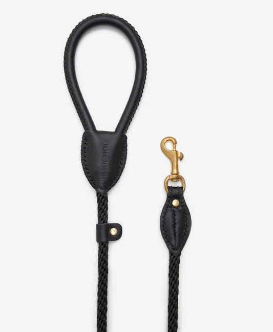 Side view of a designer black leather dog leash with gold clasp and braided rope for added strength