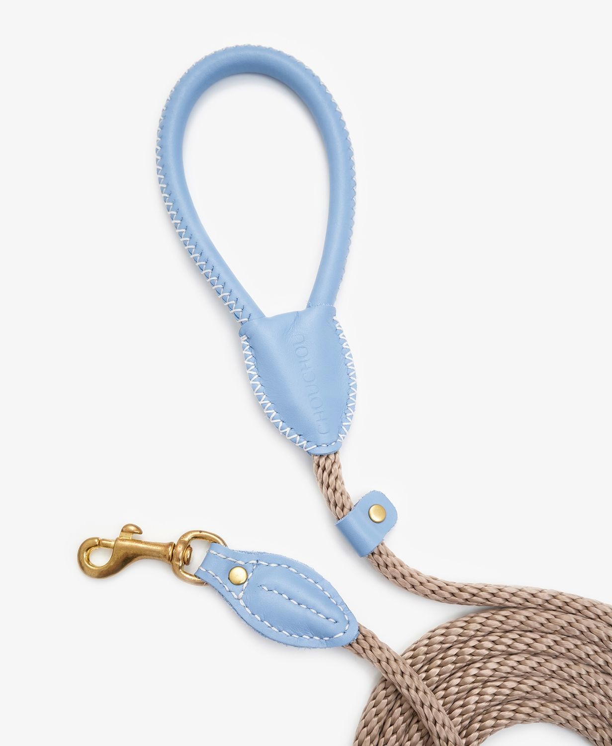 Coiled view of a premium rope dog leash with light blue leather accents and elegant brass hook