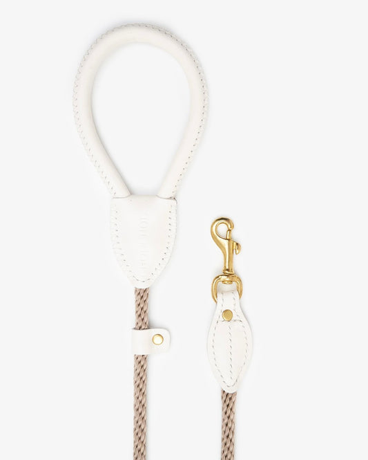 Coiled view of a premium rope dog leash with milk leather accents and elegant brass hook