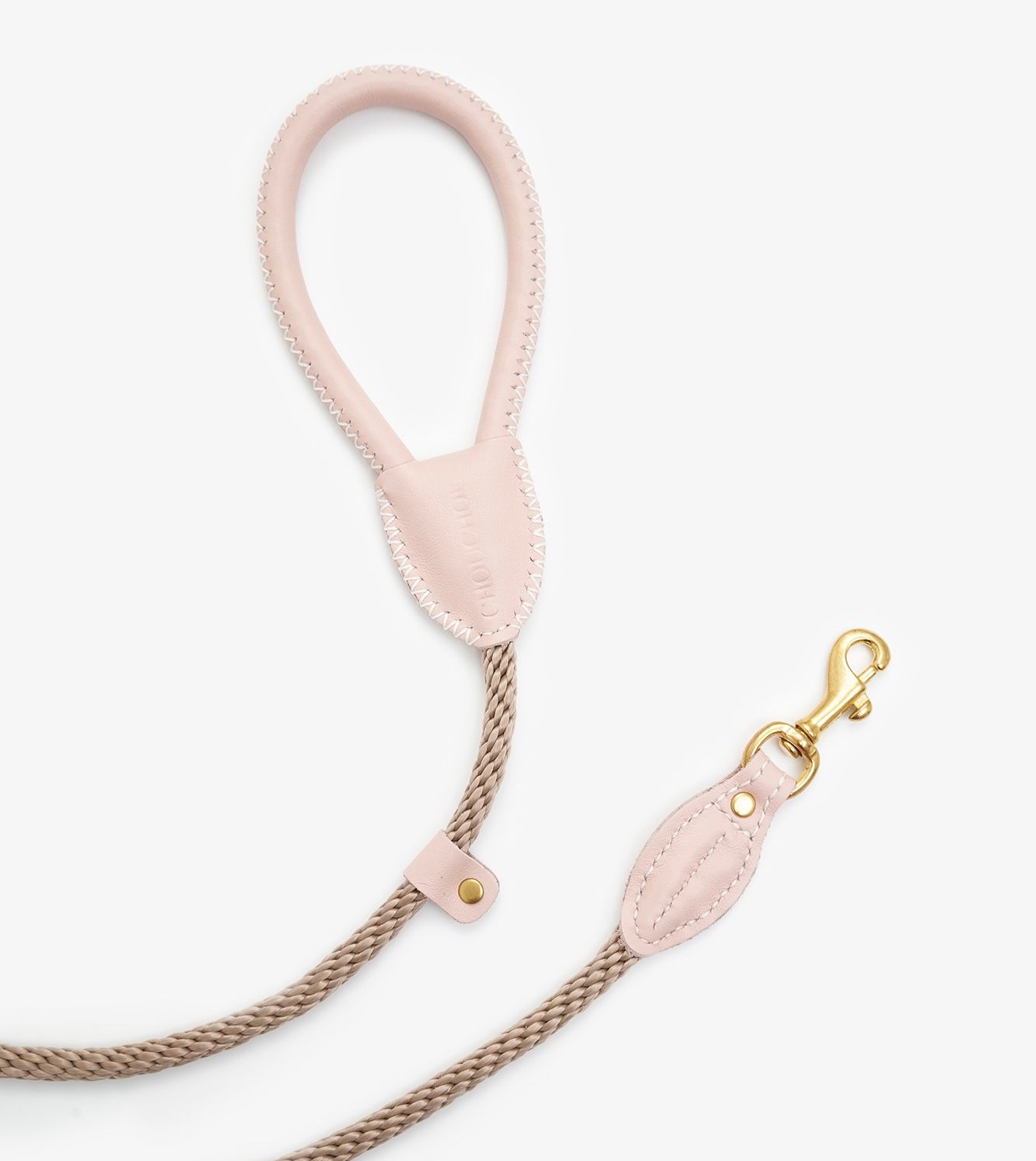 Coiled view of a premium rope dog leash with pink leather accents and elegant brass hook