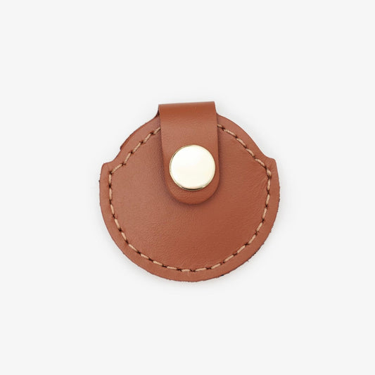 Brown leather AirTag holder with gold button, handmade from Italian leather on a white background