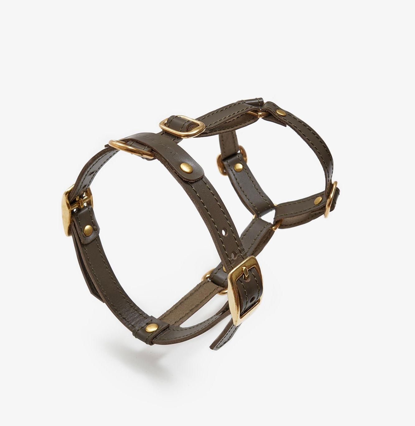 Close-up of a handmade luxury olive leather dog harness with gold hardware and an elegant design