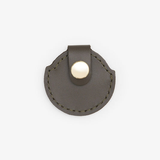 Olive leather AirTag holder with gold button, handmade from Italian leather on a white background
