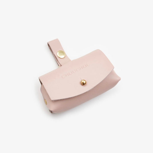 Pink Italian leather dog waste bag dispenser with gold hardware on a white background
