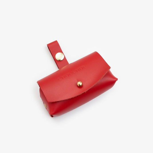 Red Italian leather dog waste bag dispenser with gold hardware on a white background